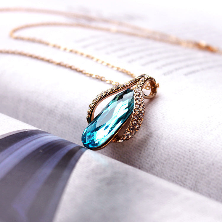 Goldfarbenes Tropfen Schmuck-Duo mit blauem Kristallstein