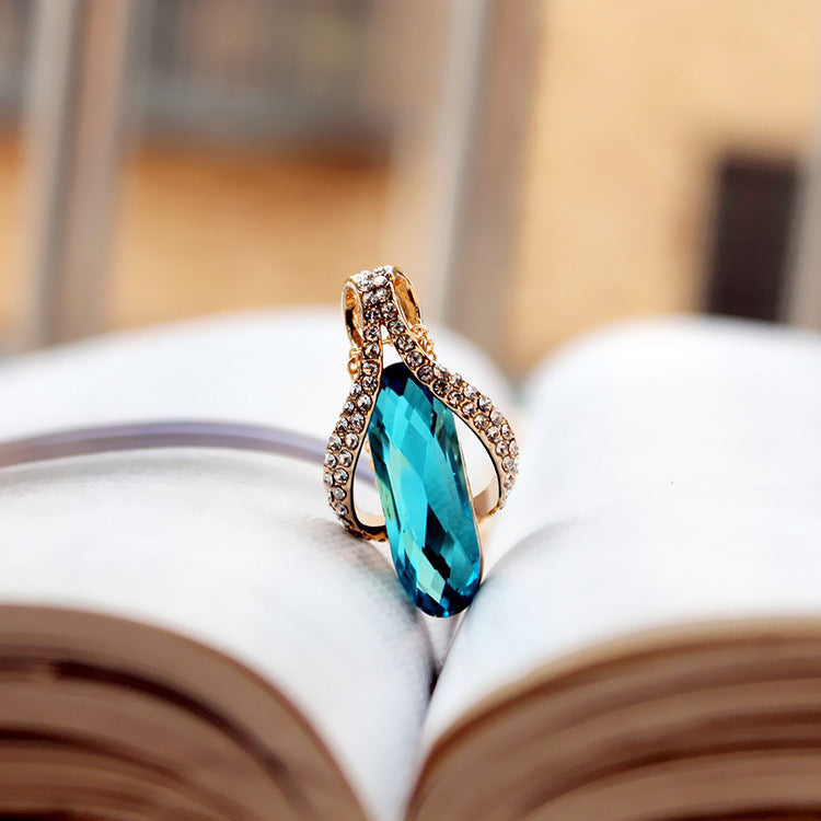 Goldfarbenes Tropfen Schmuck-Duo mit blauem Kristallstein