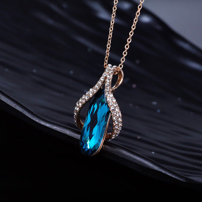 Goldfarbenes Tropfen Schmuck-Duo mit blauem Kristallstein